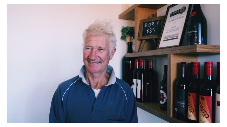 Peter Dredge from Red Edge Wine in front of the wine display in the reception area of Red Edge Wine
